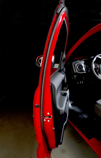 Weather strip attached to the door of a red truck