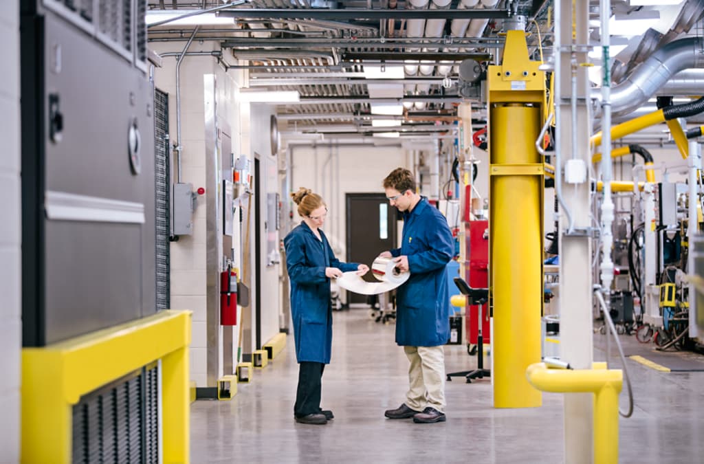 Two employees standing in a factory