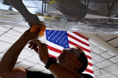 Man applying film to airplane wing