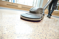 Close up of floor machine and feet, with stone floor