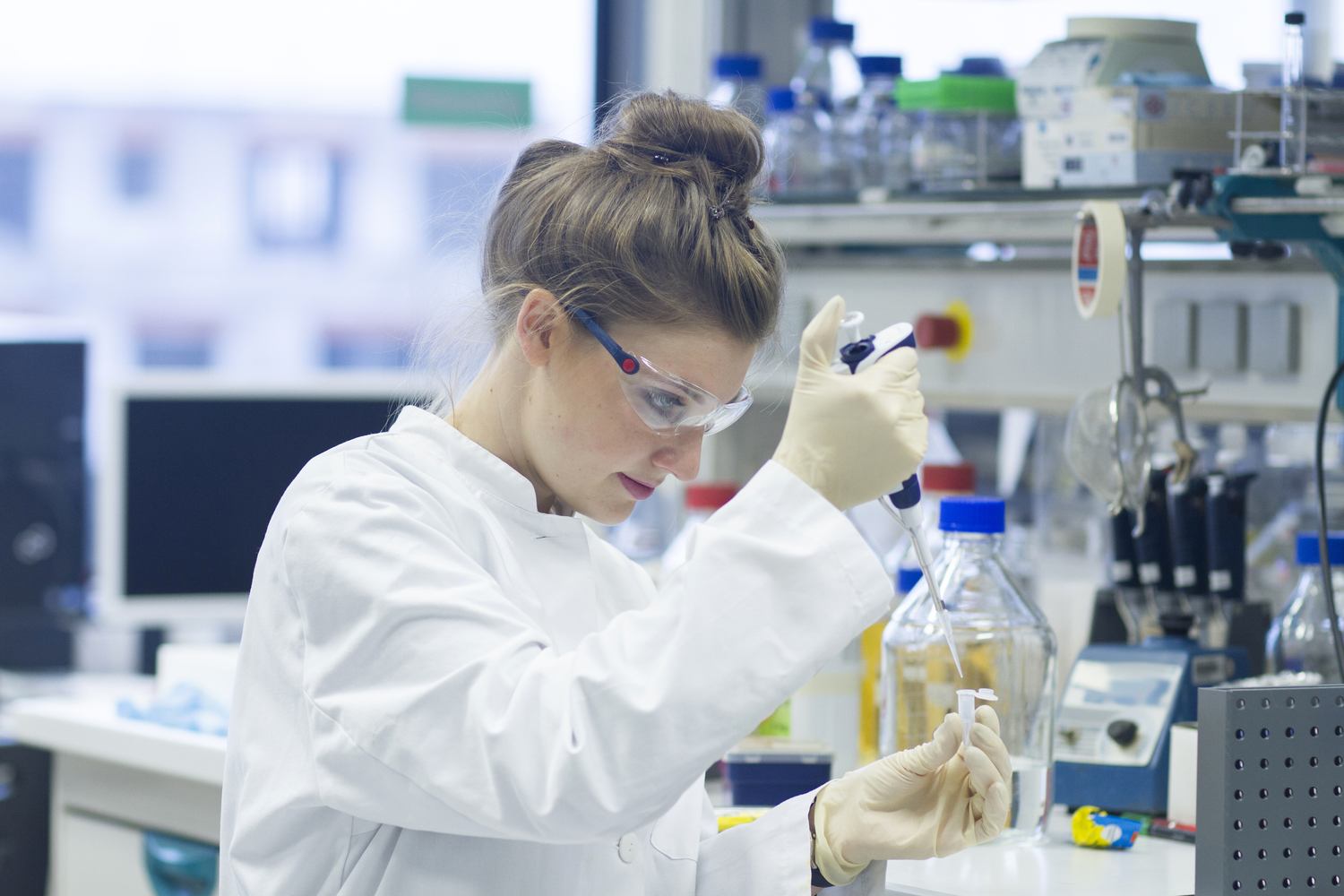 Biologist working in laboratory with pipette