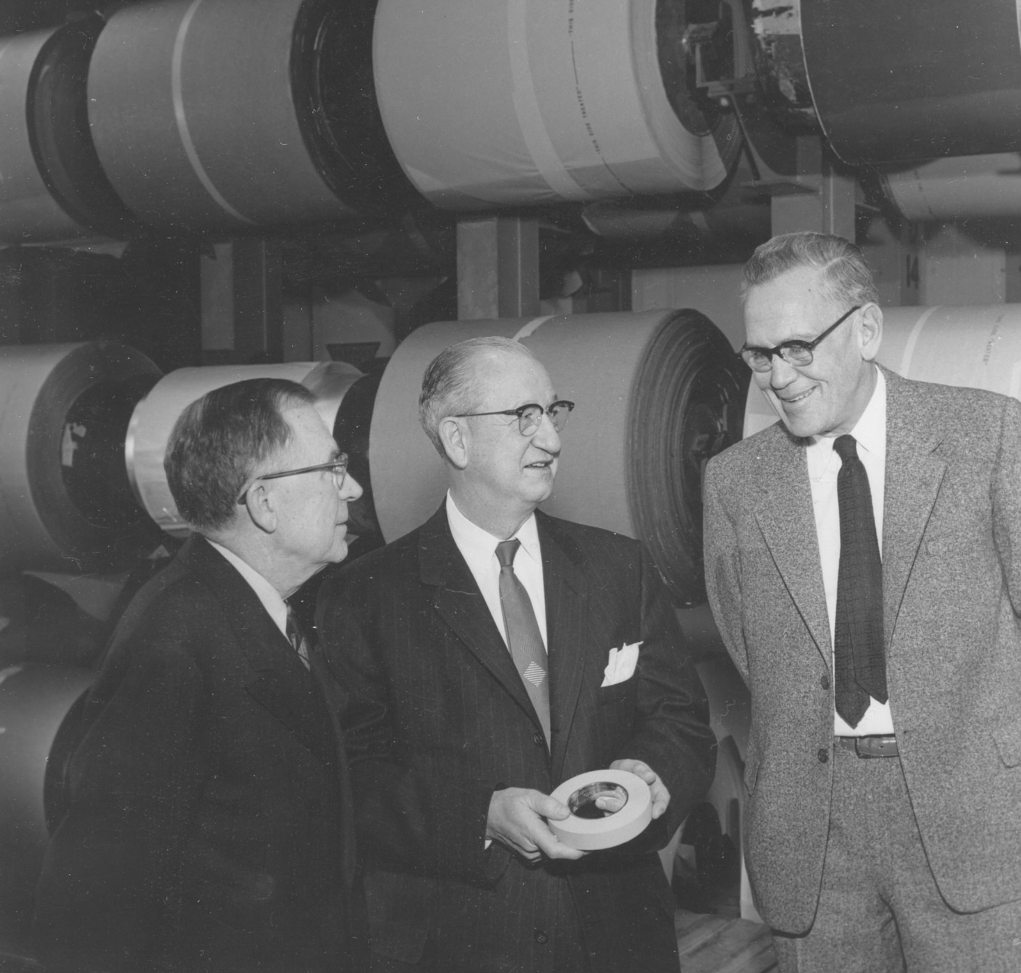 William L. McKnight marked the production of 3M's two-billionth role of tape in 1957. McKnight, left, is pictured with Herbert Buetow, 3M president, and Richard G. Drew, inventor of 3M's Scotch brand trans-parent tape and masking tape.