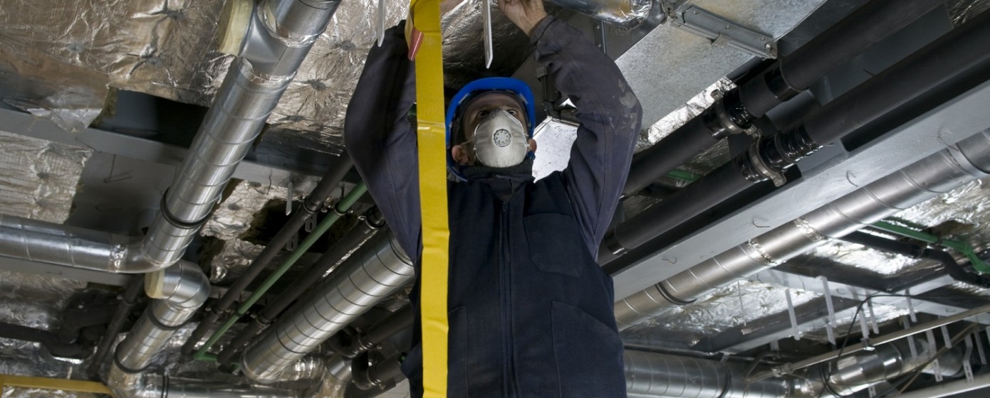 Worker Wrapping HVAC Air Duct with Foil Tape