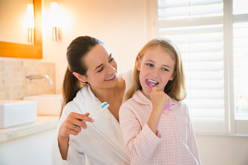 Mom and daughter brushing their teeth