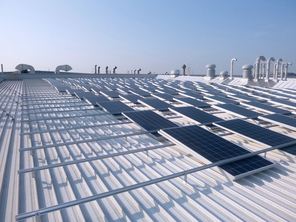 Panneaux solaires sur un bâtiment 3M avec le soleil qui brille dessus.