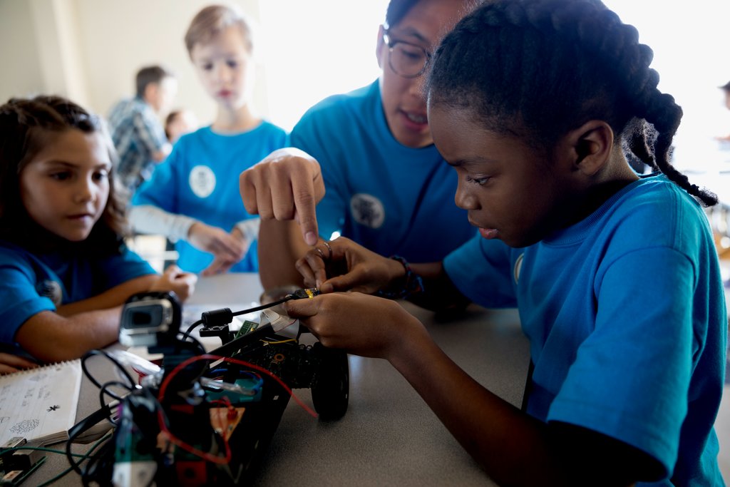 A 3M mentor helping students work through an activity.