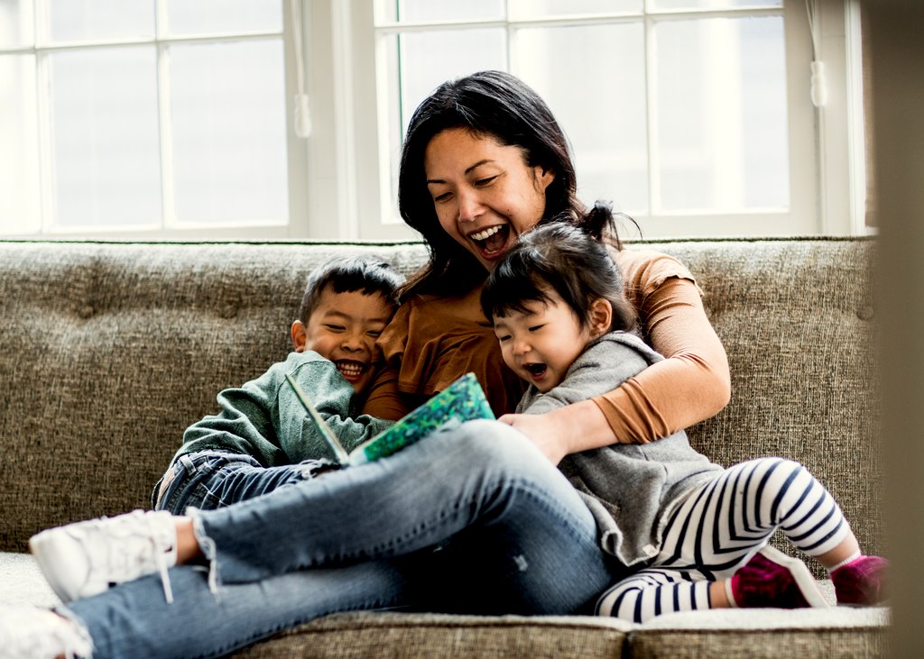  Two kids cuddling with their mom on the couch