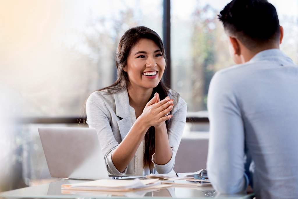 Women smiling at man while at table.  