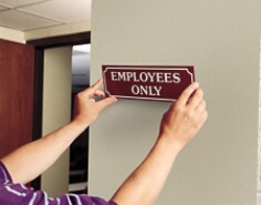 Hands putting on Employees Only sign