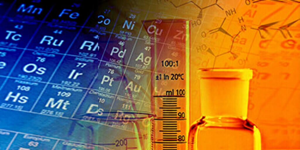 A periodic table, thermometer and bottle against a blue and orange backdrop