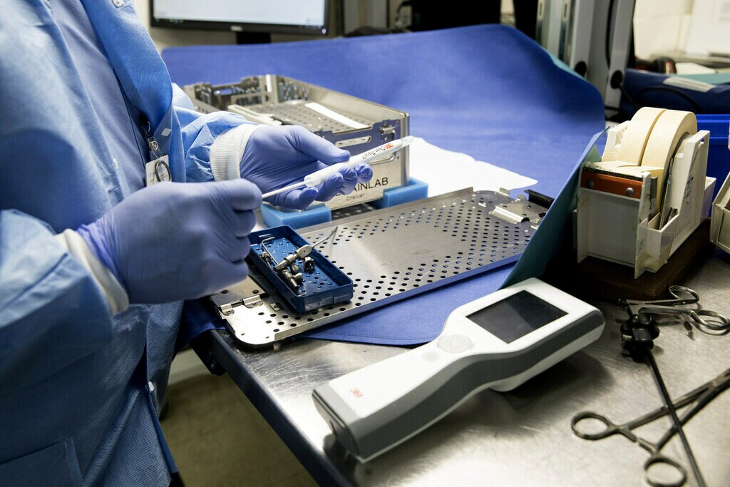 Gloved hands holding medical instruments