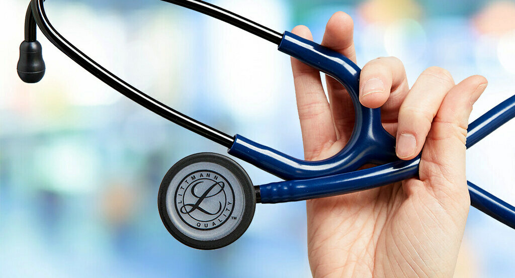 Une main tenant un Stéthoscope Cardiology IV Littmann pour l’auscultation diagnostique.  