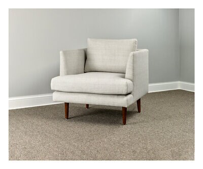 A white armchair in a carpeted room.
