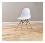 A white chair with wooden legs in the middle of a room. The chair has Scotch Glides on the feet.