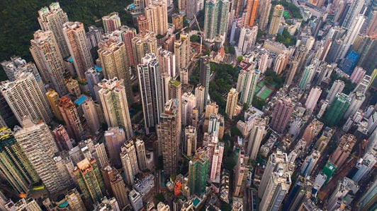 Aerial view of a densely packed urban landscape featuring numerous high-rise buildings in various colors and designs.