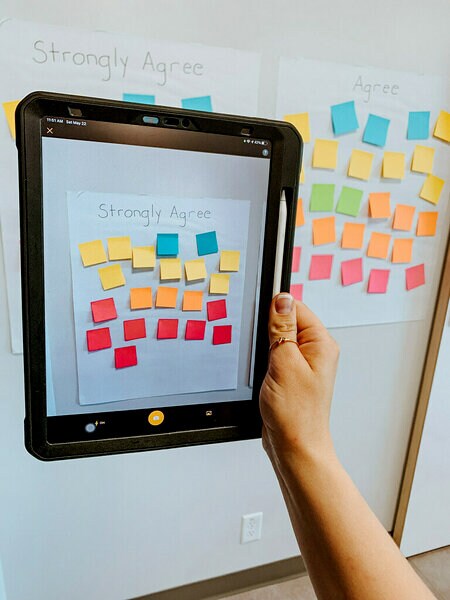 A tablet with the Post-it® App taking pictures of the Post-it® Super Sticky Notes on the Post-it® Super Sticky Mini Easel Pad paper.