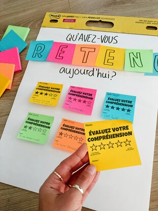 Un Mini tableau à feuilles super collantes Post-it® avec des Feuillets super collants Post-it® de différentes couleurs avec des questions écrites sur ceux-ci pour inciter les élèves à participer.