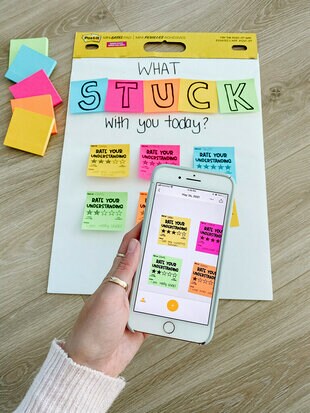 A Post-it® Super Sticky Mini Easel Pad with different coloured Post-it® Super Sticky Notes with questions written on them to prompt students to participate. A smartphone using the Post-it® App is taking  a picture of the easel pad.