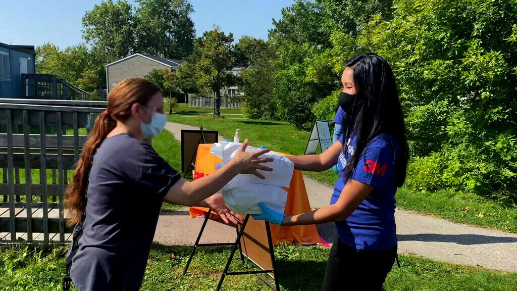 3M employee handing out a 3M Harvest Lunch meal