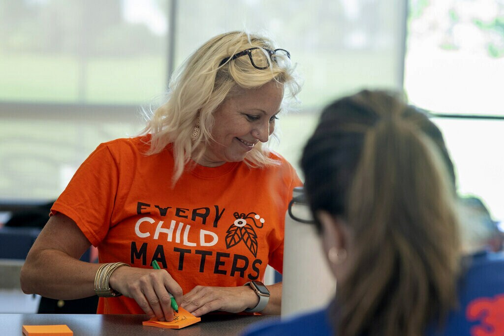 Kathie smiles while writing inspiring messages on sticky notes