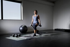 Woman lifting weights wearing ACE hinged knee brace.