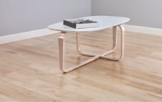 Coffee table with a book on it in the middle of a room with hardwood floors.