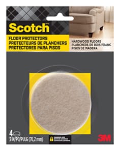 Scotch Floor Protectors in packaging.  One round floor protector is visible in the packaging. A chair sits on hardwood flooring.