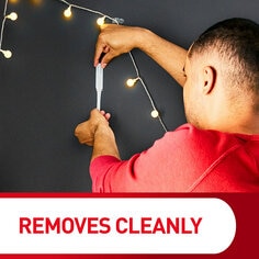 Removes cleanly. A person removes a command hook from the wall.