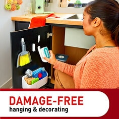 Damage-free hanging & decorating. A person hangs a cleaning tool on a hook.