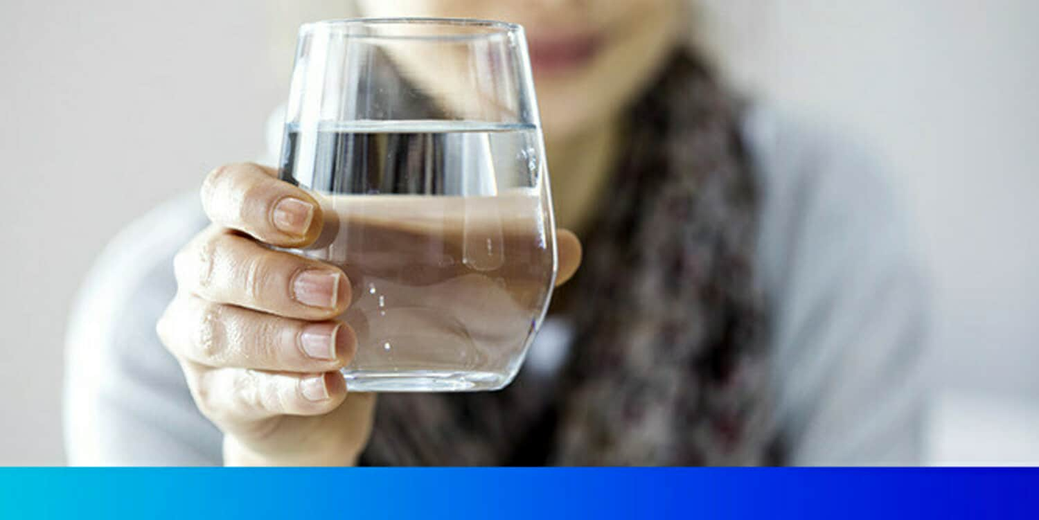 Close up photo of woman holding a glass of water