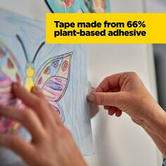 Scotch Magic Tape is made from 66 percent plant-based adhesive.  Image of a person hanging a piece of paper artwork on the wall.
