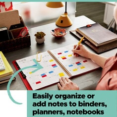 Post-it Flags help you easily organize or add notes to binders, planners, and notebooks.  Image of a person marking a personal planner.