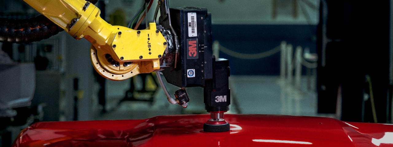 Photo of a robotic arm with 3M Finesse-it robotic paint repair head polishing a car hood