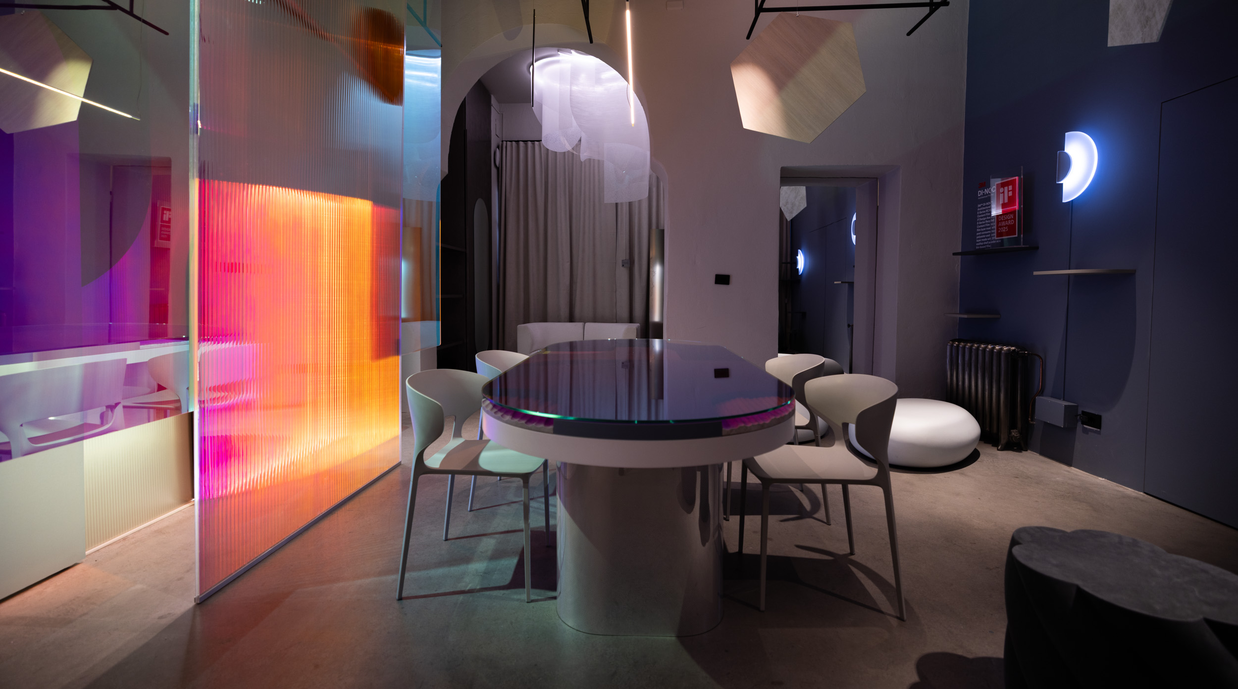 Photo of a modern interior with a table, chairs, and a translucent thin wall at Milano Design Week 2025.