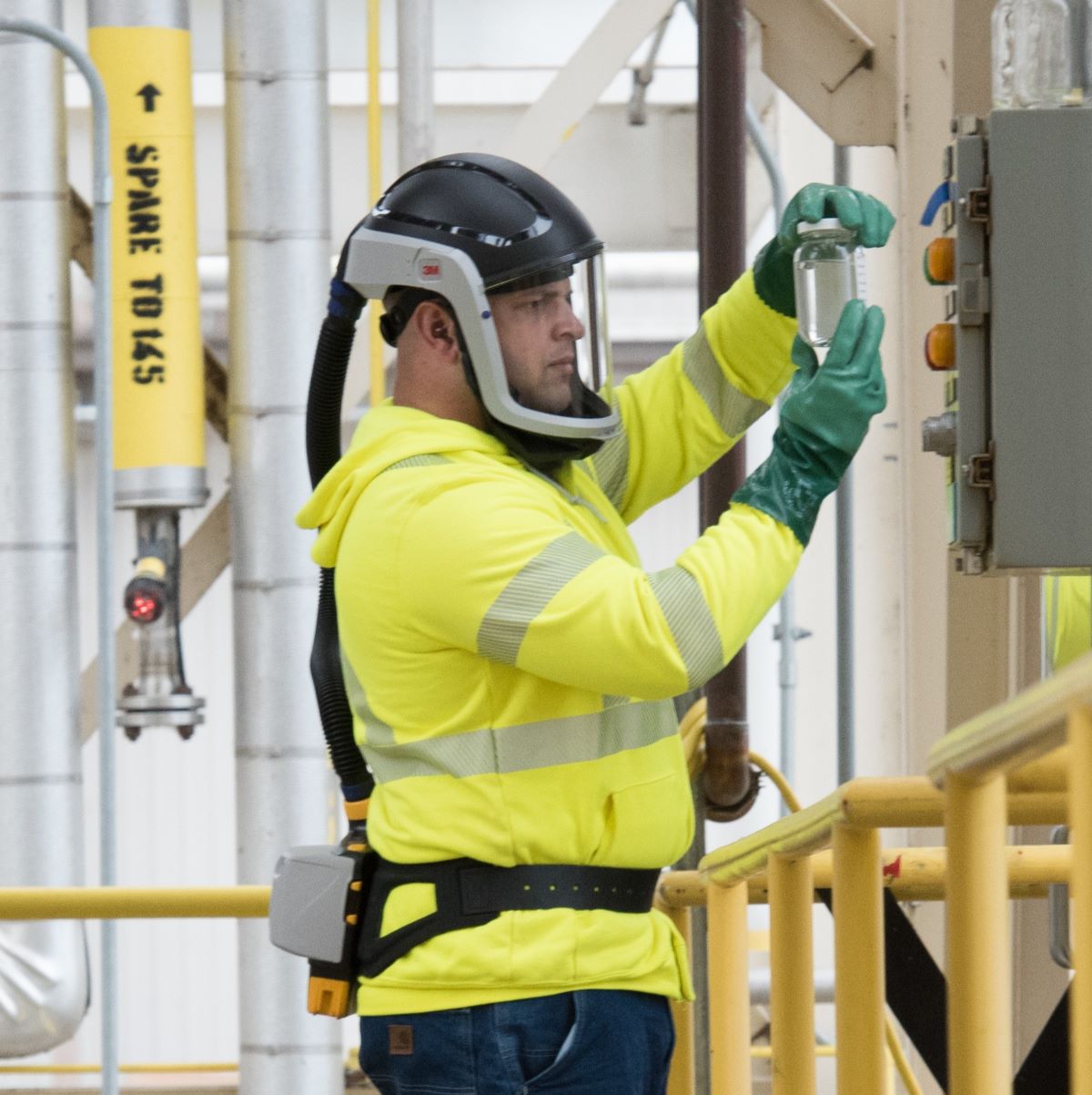 A man working in a warehouse wearing safety helmet