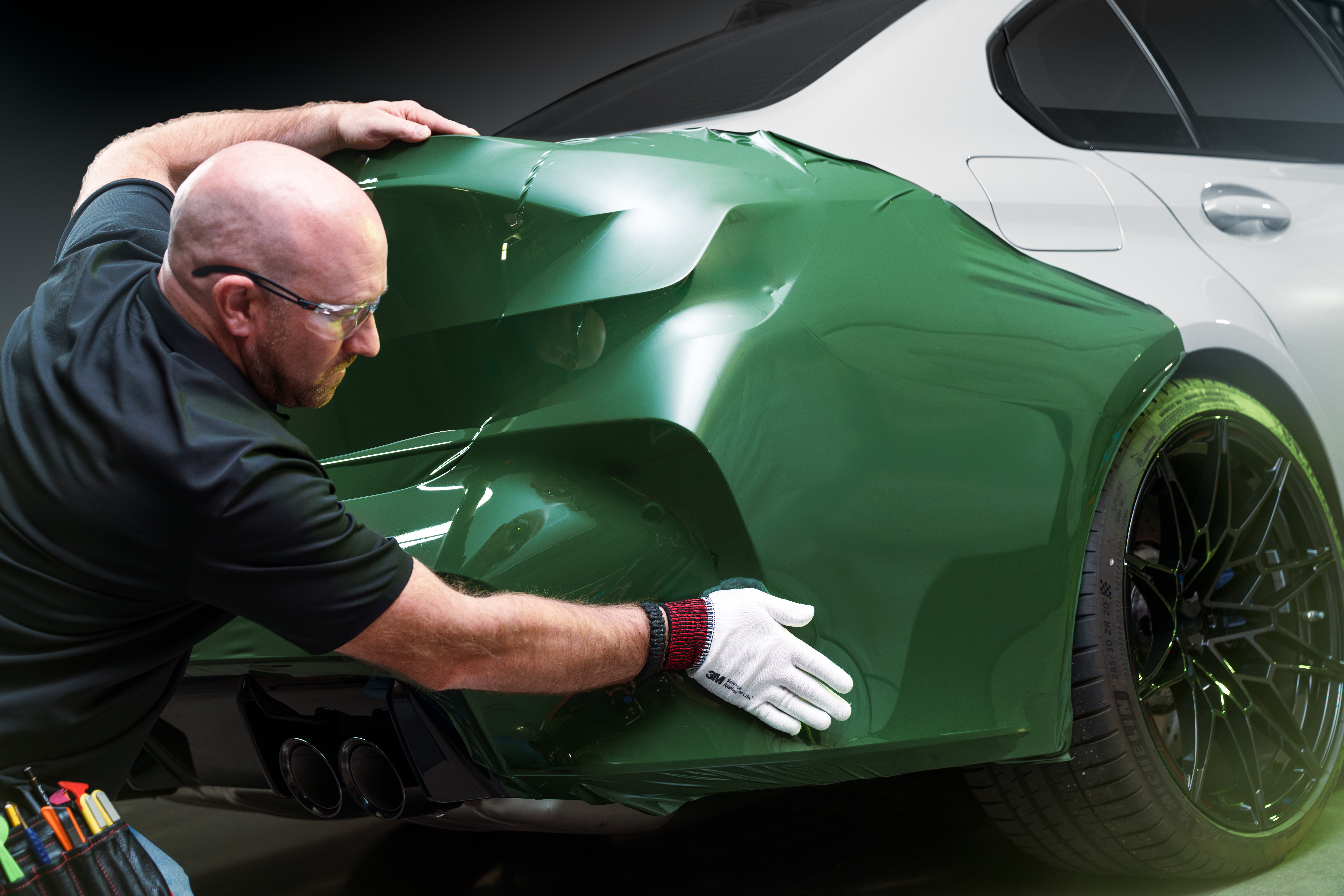 Wrap installer applying film to the back of a vehicle.