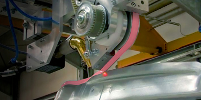 Tape being applied to an automotive component.