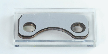 Customized die-cut section of structural adhesive tape.