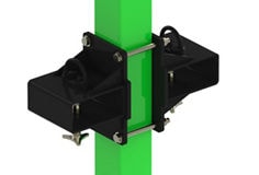 The image shows the M100 fork‑pocket kit installed on a vertical, square Flexiguard post painted bright green. Two thick, glossy‑black side plates sit on opposite sides of the post and are cinched together by two horizontal silver cross‑rods with hex nuts, gripping the post firmly. The overall impression is a compact, heavy‑duty steel bracket securely wrapped around the green post, providing opposing sleeves so a forklift can semi‑fix, position, or move the Flexiguard M100 fall‑protection system. The product is isolated against a white background with no other objects present.