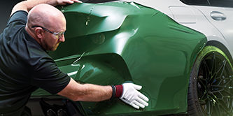  Wrap installer applying film to the back of a vehicle.