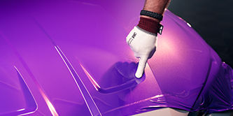  Wrap installer applying film to the hood of a vehicle.