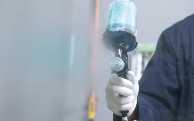 Structural adhesive primer being applied with a spray gun.
