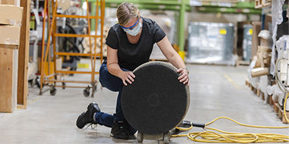 A portable floor scrubber having its floor pad replaced.