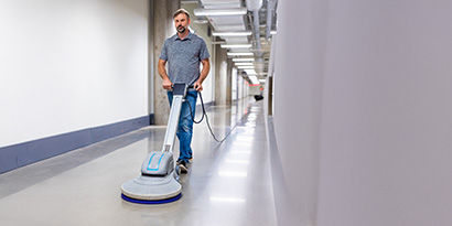 A long hallway being cleaned with a portable auto scrubber.