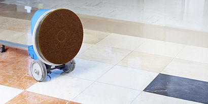 A portable floor scrubber having its floor pad replaced.