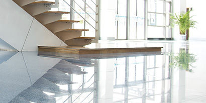 Modern stairwell landing with shiny, highly reflective floors.