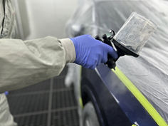 Spray Gun equipped with 3M™ PPS™ Basic Series System applying clear coat to car part in paint booth - 12