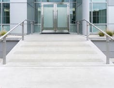 Building entrance ramp with handrails featuring 3M Safety-Walk 600 slip-resistant tread in clear