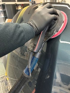 Sanding tool with cable and hose on car