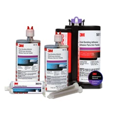 3M Panel Bonding Adhesive packages on a light gray background. Three upright containers in different sizes stand behind one smaller horizontal cartridge labeled 38315. The containers have white labels with red, purple, and blue accents, and red dispensing tips. Two translucent mixing nozzles lie in front. The largest container at right includes a 3M Performance Network Authorized Product badge.